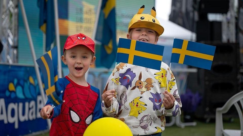 Pojkar med svenska flaggor på Vänersborgs kommuns nationaldagsfirande på Sanden i Vänersborg