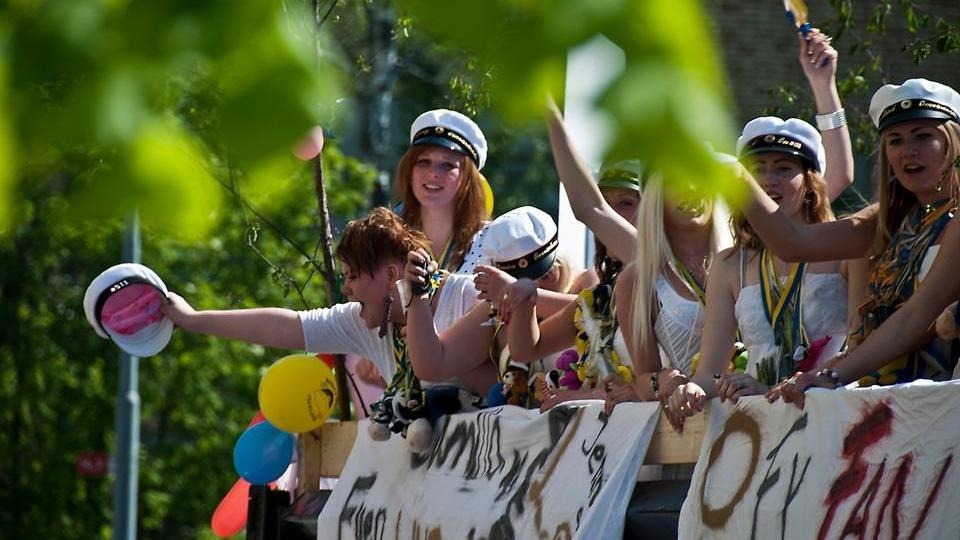 Studenten med elever som åker flak och vinkar med sina studentmössor.